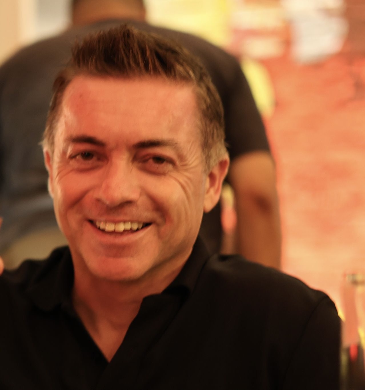 Informal portrait of James McLeary smiling in a black polo shirt.